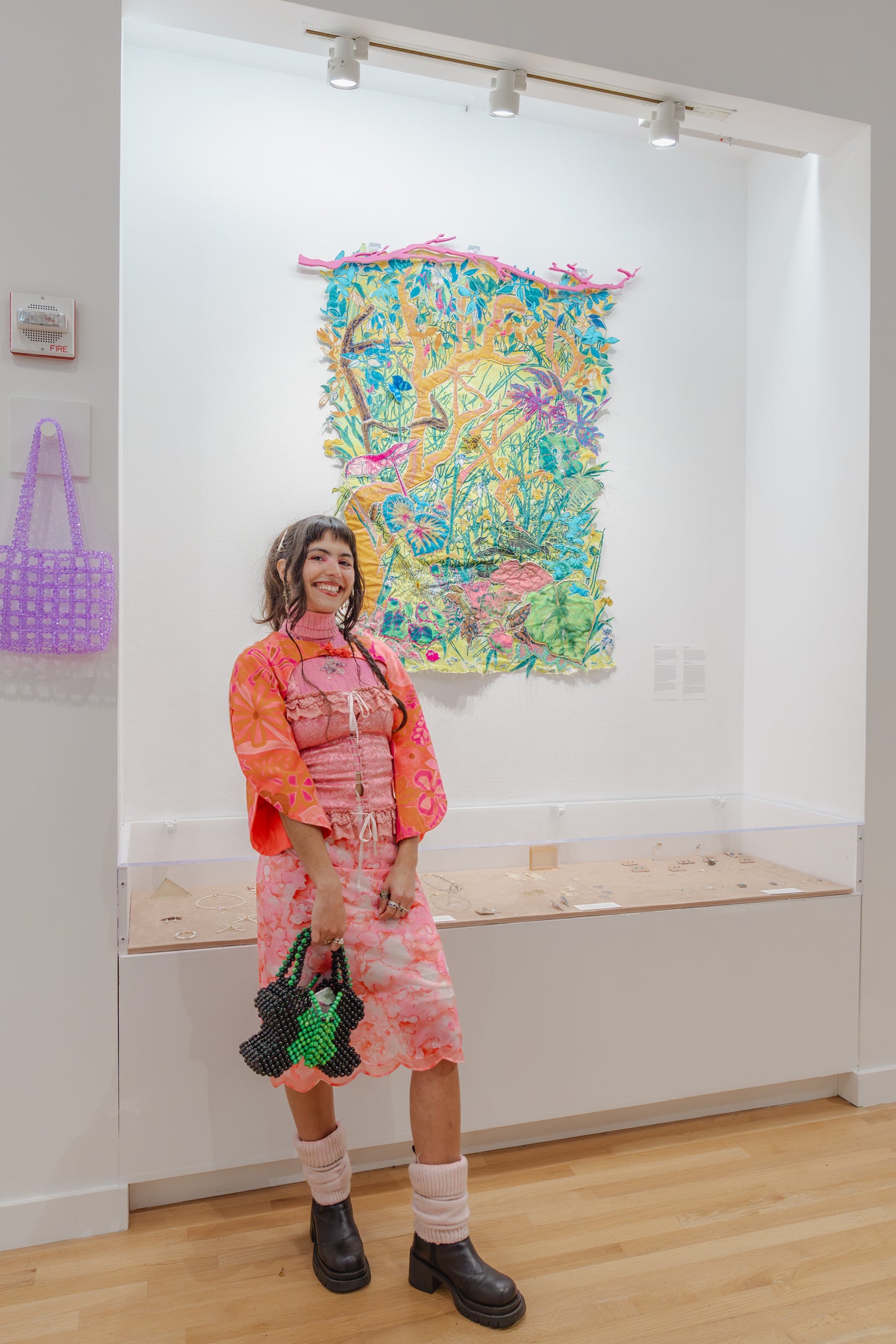 Person standing in front of a colorful abstract painting in an art gallery.